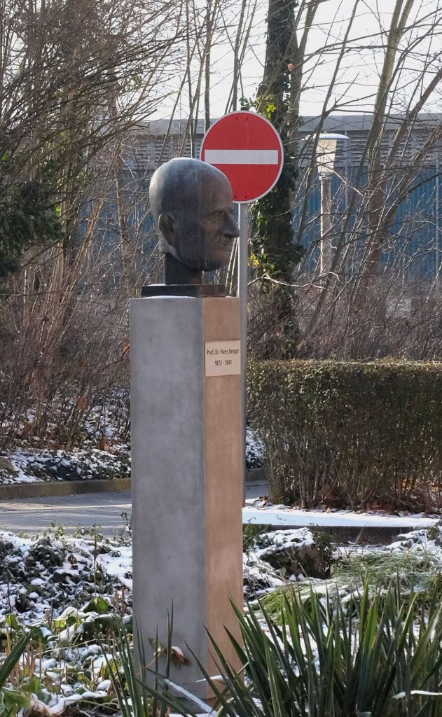 Foto der Büste von Hans Berger von der Seite vor einem Stop-Schild